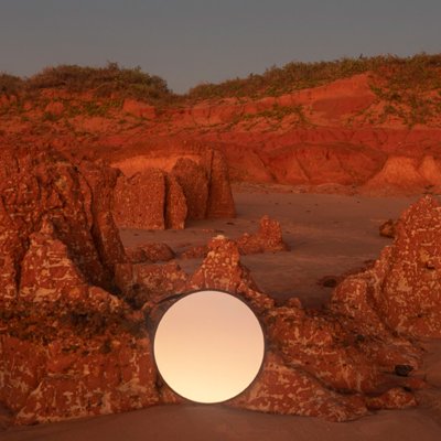 A photograph of red rocks at sunset at the beach taken by photographer Maria Maraltadj.