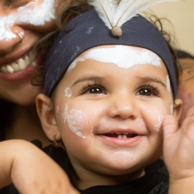 A photograph of a mom hugging her son as he looks up and smiles taken by Cole Baxter. He is a Noongar man from the Farmer family.