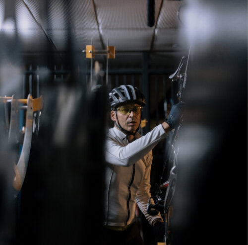 A cyclist hangs up his bike.