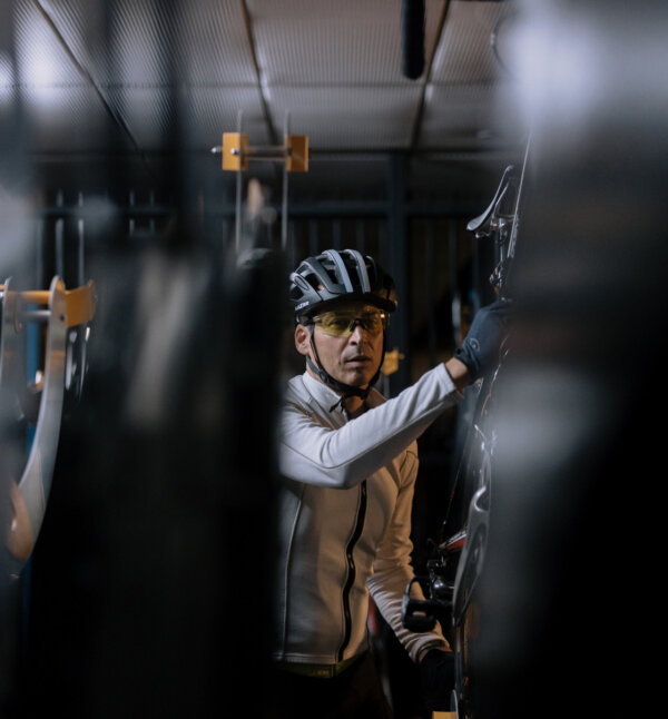 A cyclist hangs up his bike.