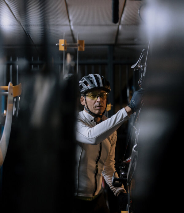 A cyclist hangs up his bike.