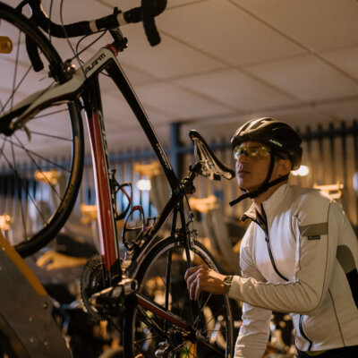 A cyclist hangs up his bike.