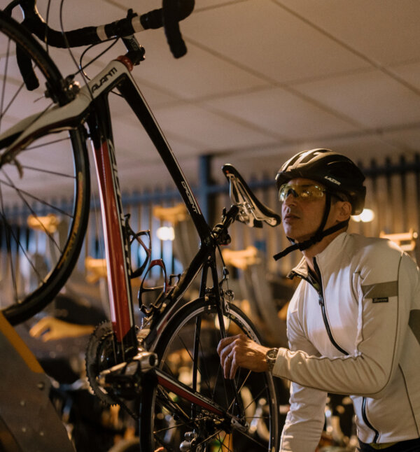 A cyclist hangs up his bike.